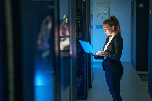 A healthcare IT worker reviews information on a laptop.