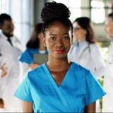 Clinician standing with a group of doctors behind her. 