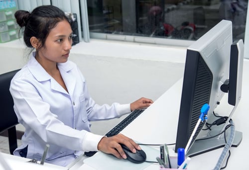 Doctor on a computer dealing with common EHR usability challenges created by a lack of EHR personalization