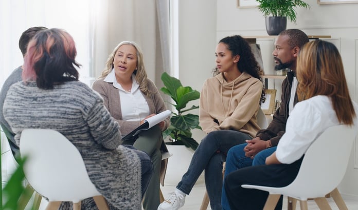 Counseling group with a group of diverse people in therapy for depression, stress, and anxiety. 
