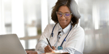 Doctor wearing glasses using a computer to access the EHR