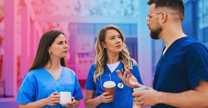 Three nurses talking outside of a hospital