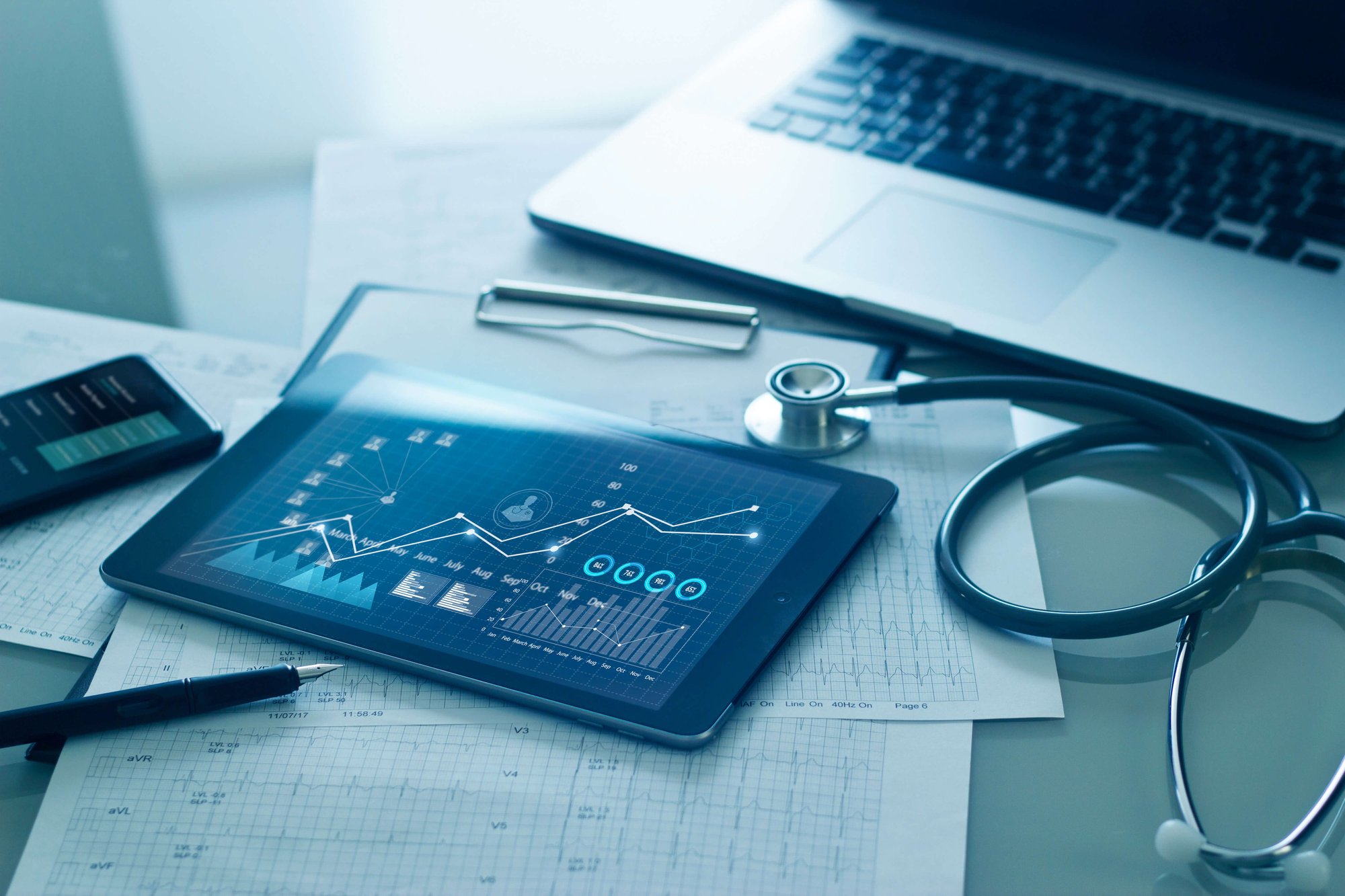 Medical examination and graph data growth of business on tablet with doctor's health report clipboard on background representing healthcare business