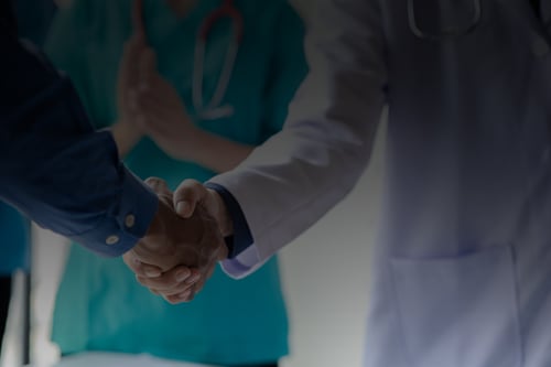 Physician and executive shaking hands