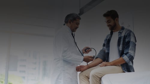 Doctor showing doctor taking patient's blood pressure