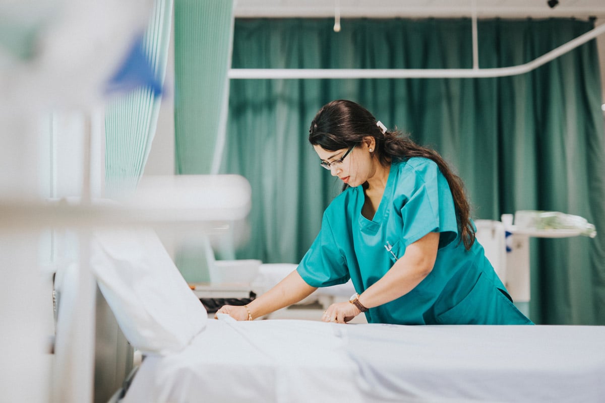 nurse resetting hospital bed